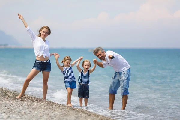 Family with two kids on the beach — Stock Photo, Image