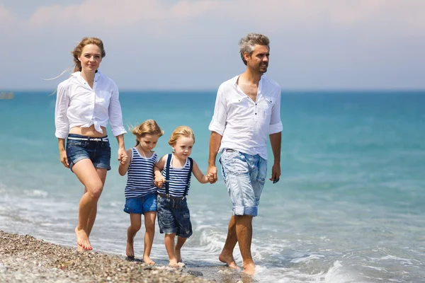 Familia con dos niños en la playa —  Fotos de Stock