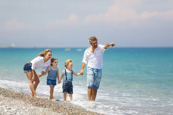 Rodina s dvěma dětmi na pláži — Stock fotografie