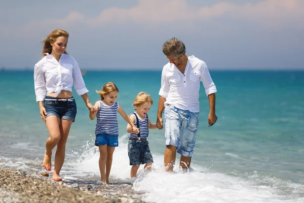 Family with two kids on the beach — Stock Photo, Image