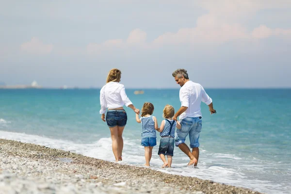 Rodina s dvěma dětmi na pláži — Stock fotografie