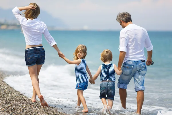 Family with two kids on the beach — Stock Photo, Image