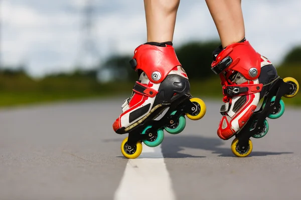 Piernas de chica que tiene ejercicio de patinaje sobre ruedas — Foto de Stock