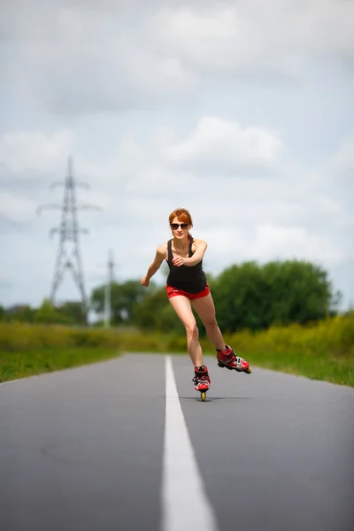 Attractive girl rollerblading on the road — Stock Photo, Image