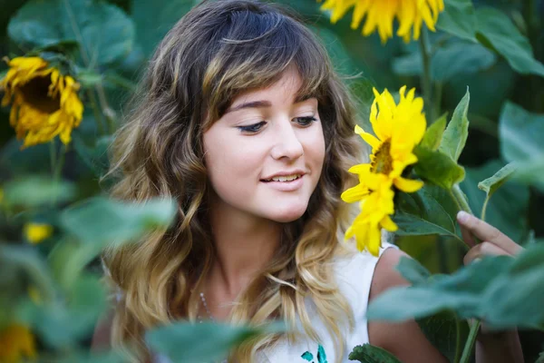 Attraktive junge Mädchen im Bereich der Sonnenblumen — Stockfoto