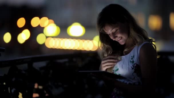 Adolescente chica usando una tableta PC en la orilla del río — Vídeos de Stock