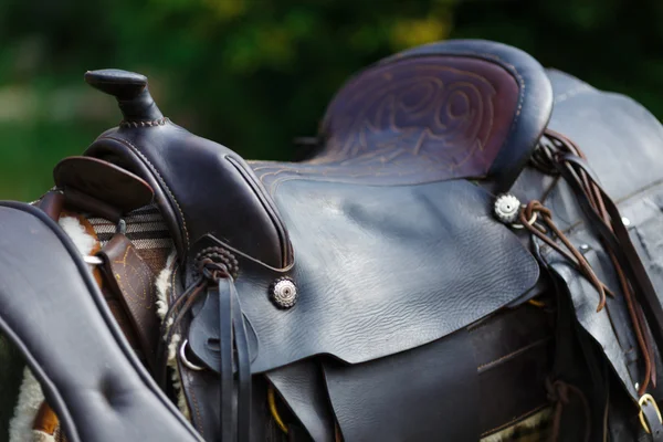 Old ornamental saddle on the wooden fence — Stock Photo, Image