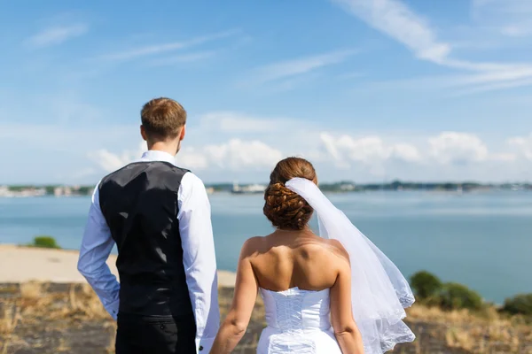 Casamento casal olhando para o mar — Fotografia de Stock