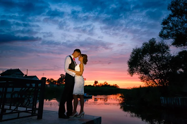 Свадебная пара влюблена на закате — стоковое фото