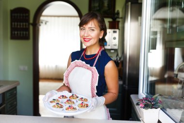Young woman holding a tray with cupcakes