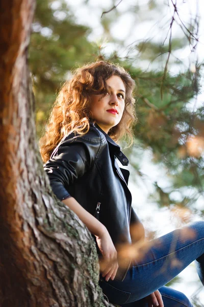 Jeune femme assise sur un arbre — Photo