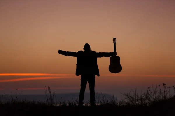 Homem com guitarra ao pôr-do-sol — Fotografia de Stock