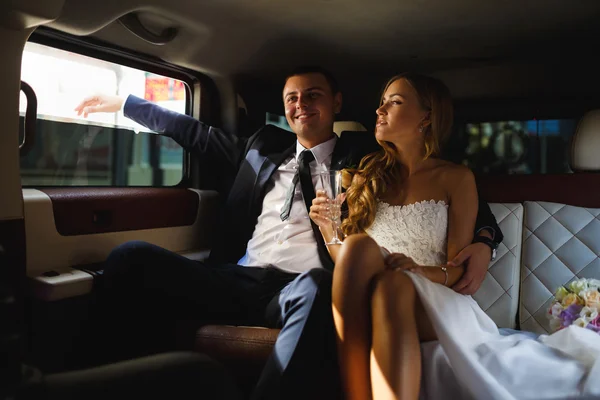 Jeunes mariés dans une voiture — Photo