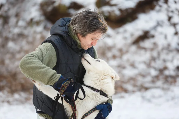 Homem abraçando com cão husky — Fotografia de Stock