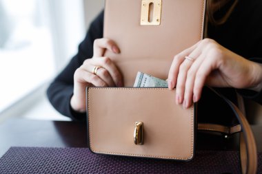 Bir yüz dolarlık banknot tutan kadın