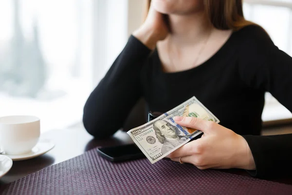 Mujer sosteniendo un billete de cien dólares — Foto de Stock
