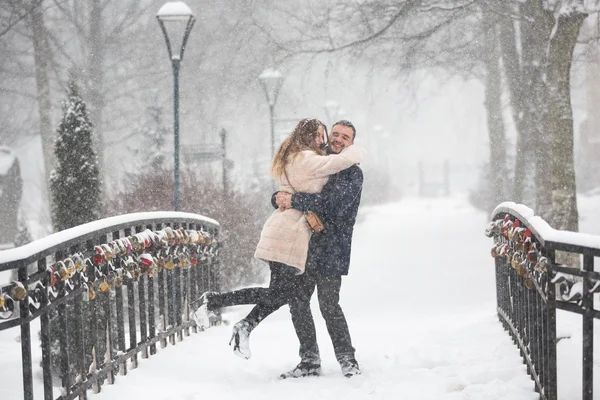 Pareja feliz en las nevadas — Foto de Stock