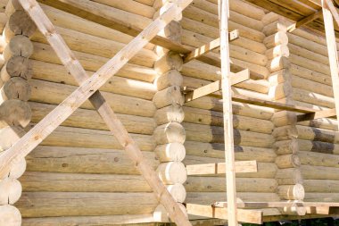 Yuvarlak kütüklerden yapılmış ahşap bir evin parçası. Günlük evin resmini kapat.