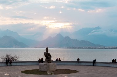 Antalya, Türkiye - 22 Şubat 2019: Antalya 'daki Eski Kaleici Meydanı' ndaki taş korkulukta oturan insanlar.