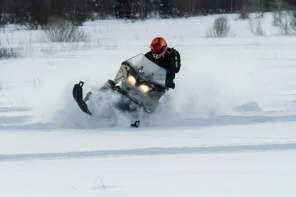 Teriberka, Ρωσία - Φεβρουάριος 24, 2018: Ο άνθρωπος σε ένα αθλητικό κράνος βόλτες με ένα snowmobile — Φωτογραφία Αρχείου