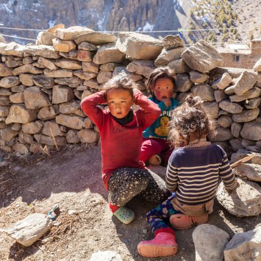 Manang, Nepal - 11 Kasım 2015: Köy caddesinde oynayan üç Nepalli çocuk
