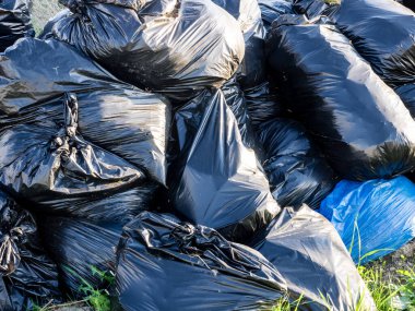 Siyah plastik torbalardaki büyük atık yığınının resmi, yasadışı çöp yığını. Ekoloji kirliliği kavramı.