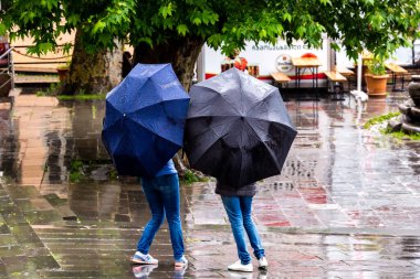 Sighnaghi, Gürcistan - 9 Haziran 2016: Sighnaghi caddesinde yağmurlu bir günde şemsiye altında iki kız