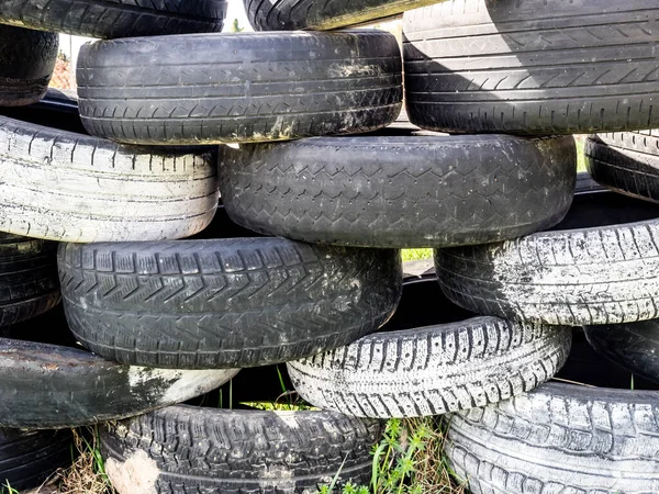 Tires stacked on top of each other. Large pile of tires dump. Illegal garbage dump. The concept of ecology pollution.