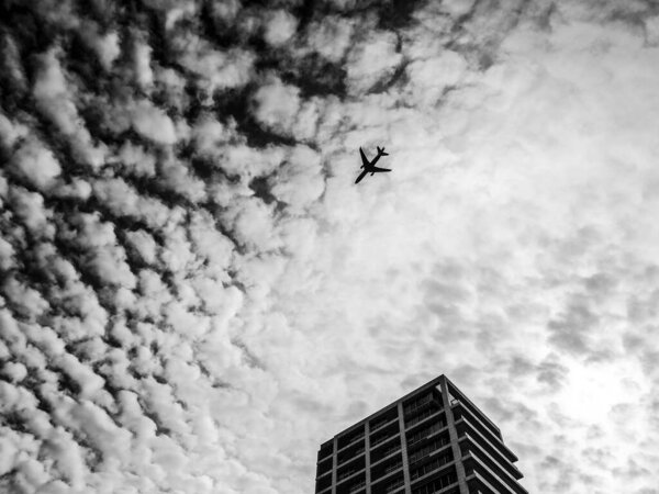 Airplane flying in the sky above the skyscraper. Tel-Aviv, Israel