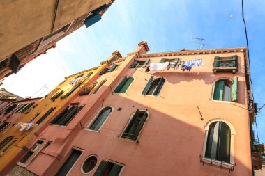 İtalya, Venedik 'te eski moda geleneksel cephe. Pencereler arasında çamaşır kuruyor. Alt görünüm