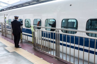 Kyoto, Japonya - 30 Aralık 2009: Kyoto istasyonundan kalkan N700 shinkansen mermi treni yakınında duran istasyon şefi