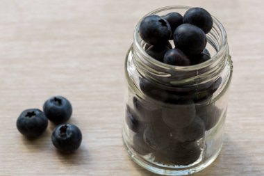 Cam kavanozda sulu olgun yaban mersini var.