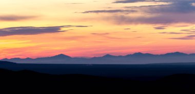 Dağlarda gün doğumu, bulutların arasından doğan güneş ışınları. Kamçatka Yarımadası, Rusya