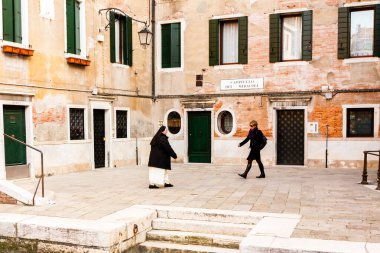 Venedik, İtalya - 11 Mart 2012: Venedik 'te antik sokağa çıkan iki kadın