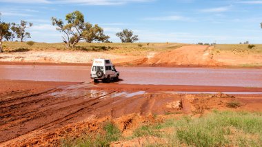 Alice Springs, Avustralya - 30 Aralık 2008: Avustralya 'nın kuzeyindeki kırsal yolda nehrin karşısına geçen off-road otomobil