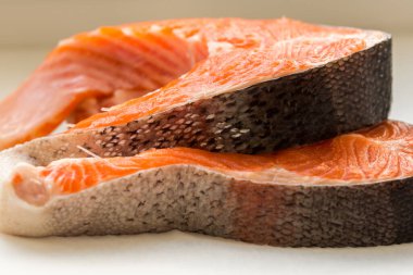 Beyaz arka planda iki çiğ alabalık filetosu.