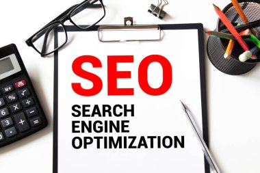 Kelime yazma Seo Targeting. Konum İniş Sayfası Üst Alan Adamı için Özel Anahtar Sözcükler iş konsepti. Elinde işaret defteri, çamaşır mandalı, hatırlatıcı tahta masa fincanı kahve fincanı..