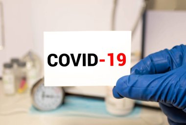 Orta yaşlı, tıbbi maske takan, elinde Covid-19 kartı olan Asyalı bir kadın. Beyaz arka planda Covid 19 Corona virüsünden sağlık hizmetlerini teşvik edin..