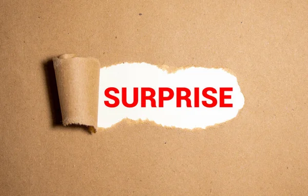 Kahverengi yırtık kağıdın altına yazılmış sürpriz sözcük.