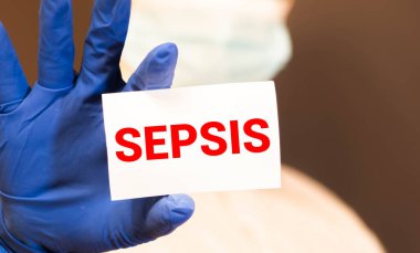 Doktor elinde yazılı bir kart tutuyor. Sepsis, tıbbi konsept..