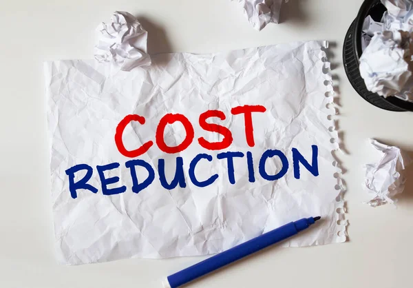 Cost Reductions words on copybook page, Business concept for reduction expenses for goods and services.