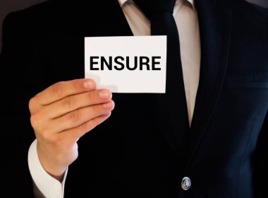 ENSURE kelimesi gözlüklü bir defterde yazılıdır.