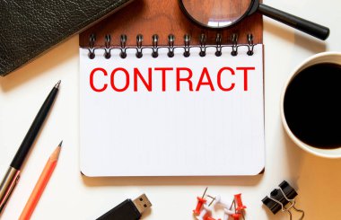 Sözleşmeli. ConTRACT kelimesi gözlüklerin yakınındaki hafif bir deftere yazılmıştır. Ahşap bir arka planda hesap makinesi. İş konsepti. Düz yatıyordu.