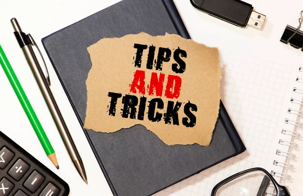 Tips and tricks written on book with wooden background.