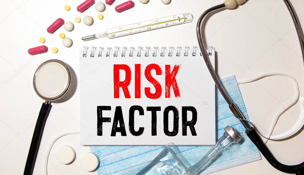 Risk Factor handwritten on paper note with stethoscope on wooden table.