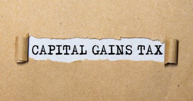 Üzerinde CAPITAL GAINS Vergi yazan bir kart tutan işadamına yakın plan, yumuşak odaklı iş konsepti resmi ve klasik ton