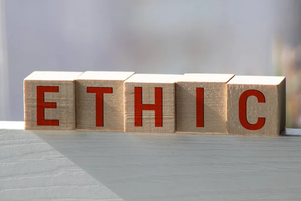 Wooden blocks with the word Ethic. Defending, systematizing and recommending concepts of right and wrong conduct. Moral philosophy