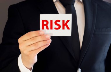 RISK - sarı arkaplanda kırmızı harflerle yazılmış kelime.