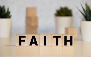 Küp bloklardaki ahşap bir masada FAITH mesajı
