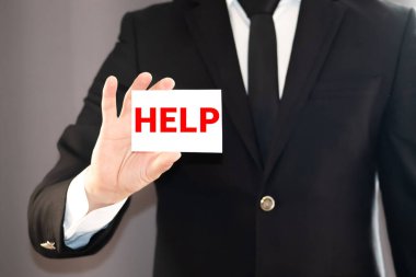 Adamın ev ödevinde yardıma ihtiyacı var. Elinde kağıt olan küçük çocuk Yardım sözcüğü.